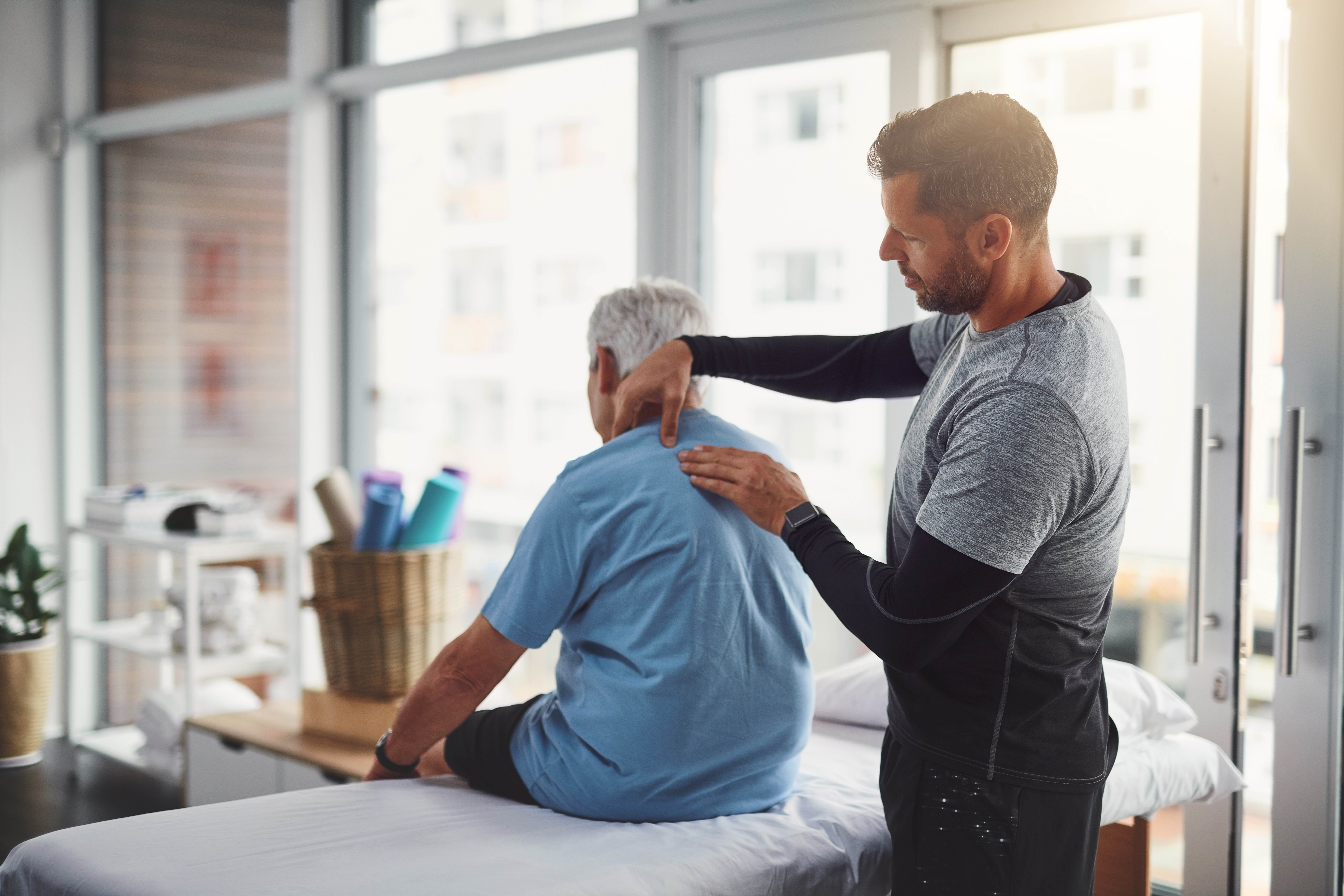 Male physiotherapist working on an older male patient in his physiotherapy clinic Male physiotherapist working on an older male patient in his physiotherapy clinic